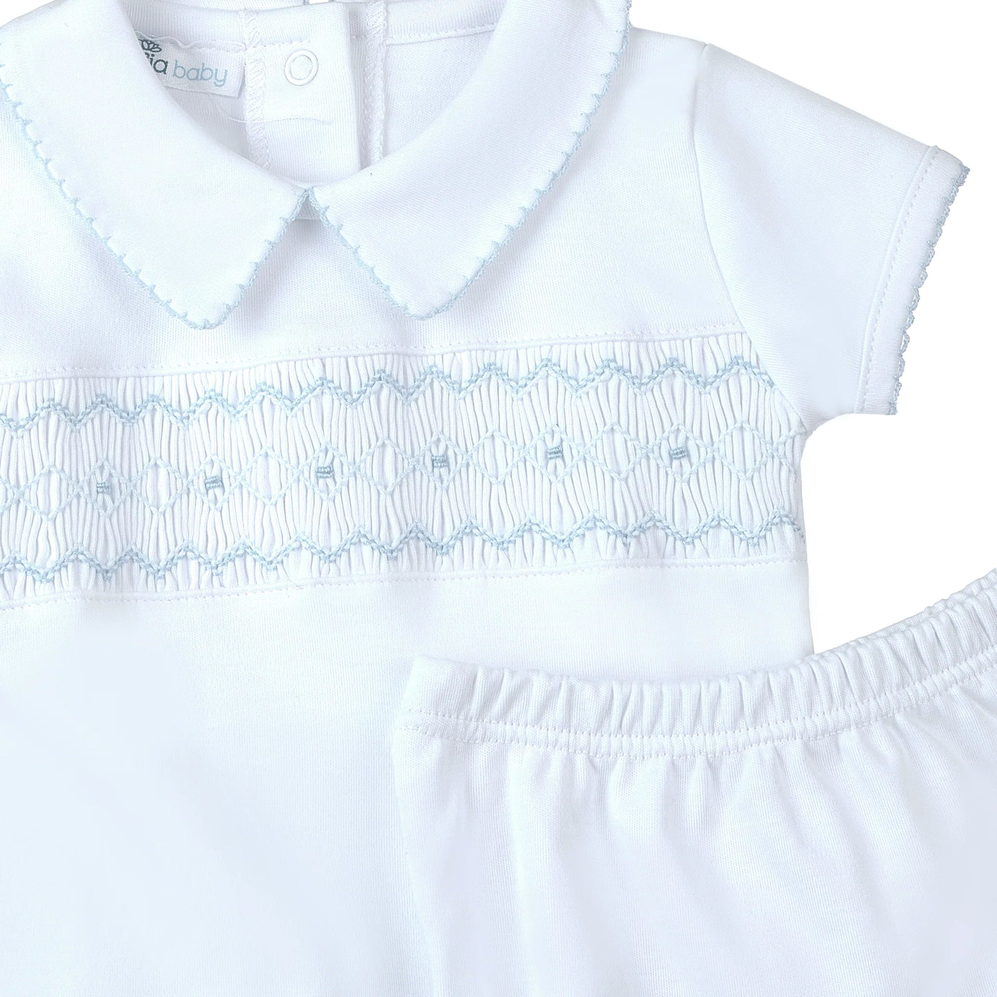 White dress with blue embroidery on a white background