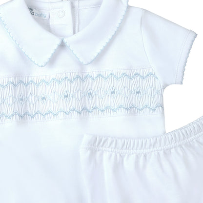 White dress with blue embroidery on a white background